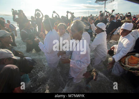 Bantul, Yogyakarta, Indonesia. 11th Mar, 2018. YOGYAKARTA, INDONESIA - MARCH 11 : Balinese Hindu pray during Melasti ceremony at Parangkusumo beach on March 11, 2018 in Yogyakart, Indonesia. Melasti is a Hindu Balinese purification ceremony and ritual, which according to Balinese calendar is held several days prior to the Nyepi holy day. Melasti was meant as the ritual to cleanse the world from all the filth of sin and bad karma, through the symbolic act of acquiring the Tirta Amerta, ''the water of life''.Melasti ceremony is held on the edge of the beach with the aim to purify oneself of a Stock Photo