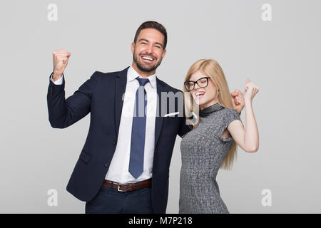 Happy young successful caucasian businesspeople arms raised when winning, toothy smile Stock Photo
