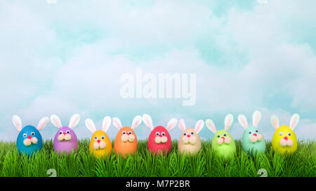 Colorful decorated Easter Eggs with bunny faces and ears lined up in a row on green grass, vintage sky background. Fun Easter concept. Banner format f Stock Photo