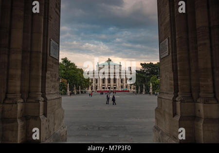 Long shot of Burgtheater in Vienna framed through the arch of Rathaus as the theatre lights come on Stock Photo