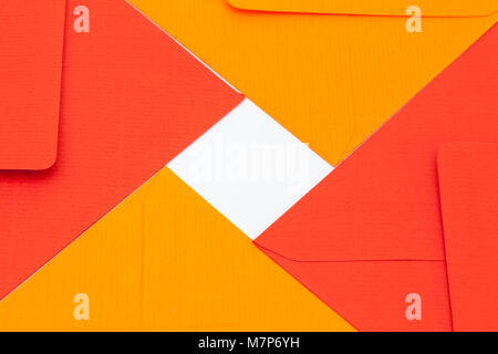 Pattern from red  and orange envelopes on the white table Stock Photo