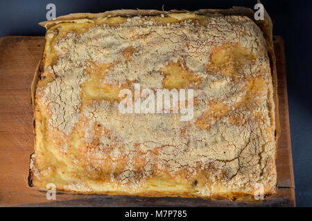 whole homemade cheesecake with raisins served on wooden tablet Stock Photo