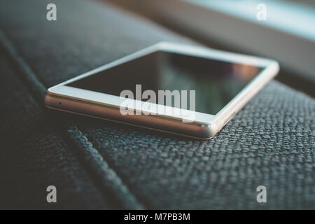 Business Smartphone Lying On The Armrest Of A Couch Stock Photo