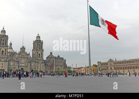 The national flag of Mexico waves above the Mexico City zocalo, one of the largest public squares in the world surrounded by historic architecture. Stock Photo