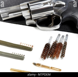 Snubnose revolver laying on table with gun cleaning tools isolated on a black mat Stock Photo