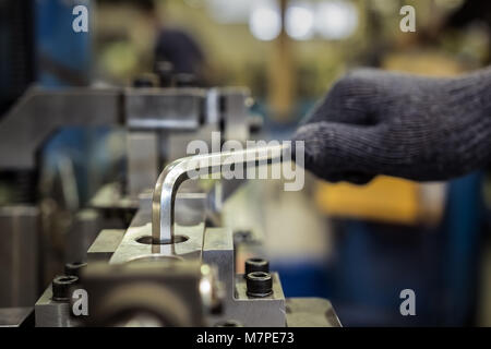 Worker is used Hexagonal screwdriver in factory Stock Photo