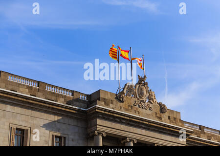 Spanish and Catalonian Flags on Stone Crest of Government Building Stock Photo