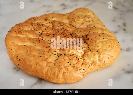 Turkish flat bread with sesame on marble countertop