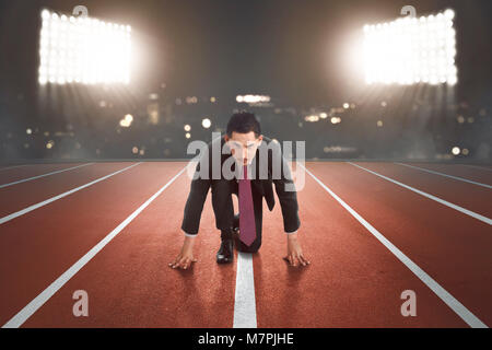 Young asian businessman ready for running with light on the background Stock Photo