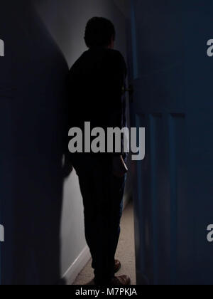 Creepy middle aged man entering a dark room looking like a thief Stock Photo