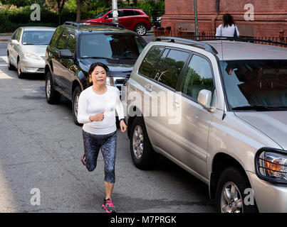 A 65 year old woman of Japanese heritage running in NYC. Stock Photo