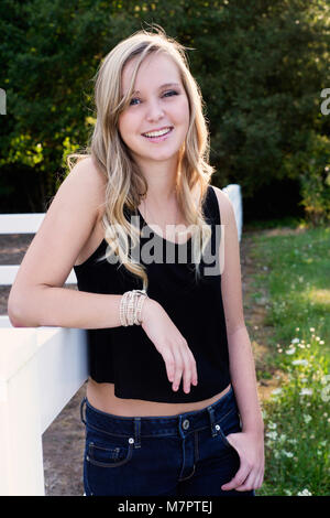 Self assured young woman with long curly red hair in casual clothes ...