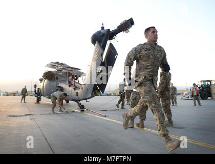 U. S. Air Force Master Sgt. Christopher Clark, 455th Expeditionary Aircraft Maintenance Squadron, production superintendent  rushes to pick up equipment to move an HH-60 Pave Hawk at Bagram Airfield, Afghanistan June 9, 2014. Helicopter maintainers here ensure Bagram’s combat search and rescue helicopters are ready to fly at a moment’s notice. Clark is deployed from Moody Air Force Base, Ga. and a native of Stratham, N.H.   (U.S. Air Force photo by Staff Sgt. Evelyn Chavez/Released) 455th Air Expeditionary Wing Bagram Airfield, Afghanistan Stock Photo