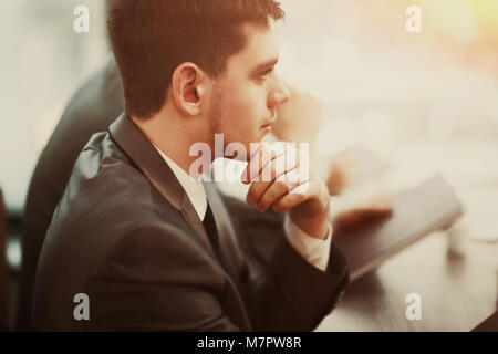 Casual businessman thinking with team behind him in office Stock Photo
