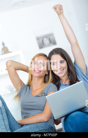 two astonished roommates watching media content on line Stock Photo