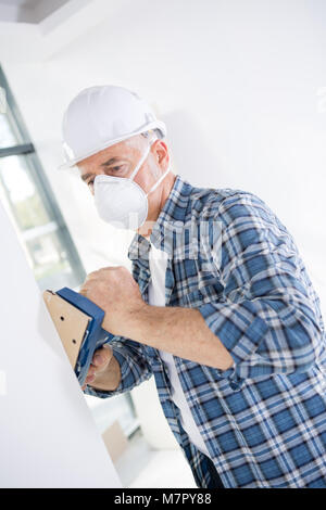 man sanding plasterboard Stock Photo