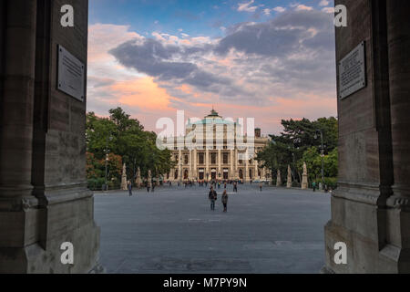 Long shot of Burgtheater in Vienna framed through the arch of Rathaus as the theatre lights come on Stock Photo