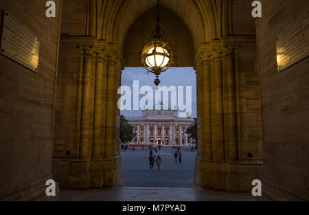 Long shot of Burgtheater in Vienna framed through the arch of Rathaus as the theatre lights come on Stock Photo