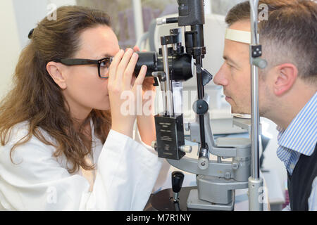 female optometrist examining a patients eye Stock Photo