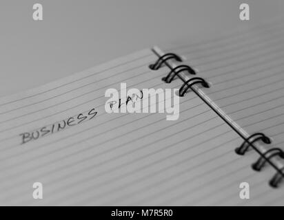 Empty notebook waiting for a business plan, Business plan title on empty sheet of white paper. Spiral notebook. Stock Photo