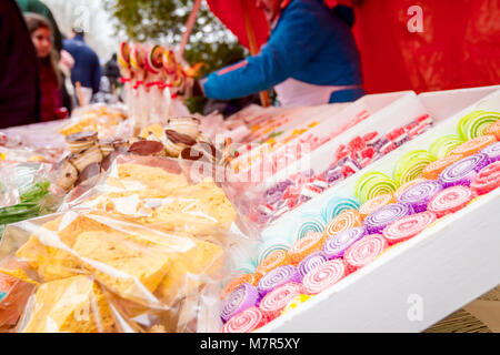 Various colored candies and sweets for sale placed in trays, available at flea market. Stock Photo