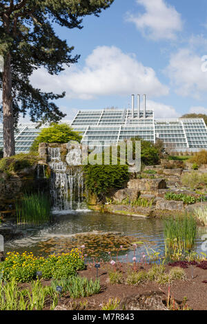 London, UK - April 18, 2014. Rock garden and Princess of Wales Conservatory in Kew Botanic Gardens. The gardens were founded in 1840. Stock Photo