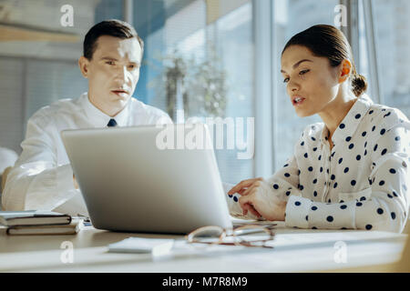 Pleasant colleagues working on common project on laptop Stock Photo