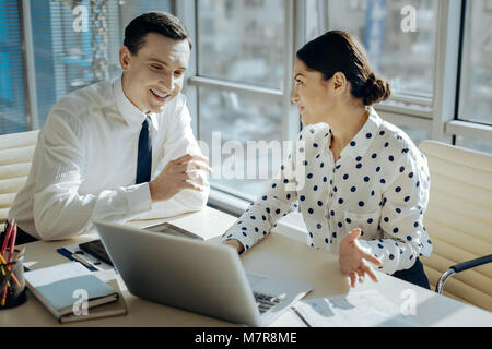 Charming female boss commenting on employees report Stock Photo