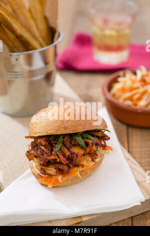 A vegan 'pulled pork' style slider made with jackfruit, plus a side of chips and coleslaw. Stock Photo