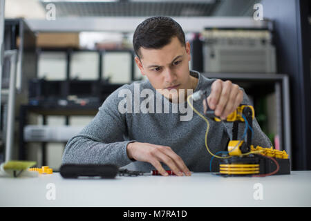 Young adult studying robotic arm Stock Photo