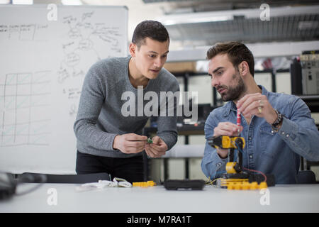 Colleagues working on robotics Stock Photo