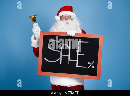 Portrait of santa claus holding blackboard and bell Stock Photo