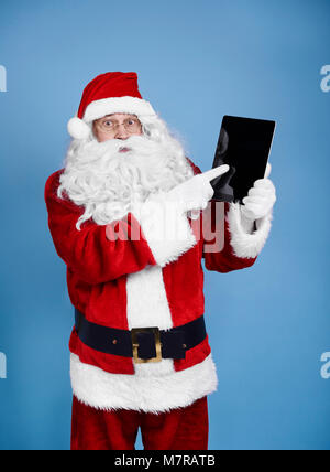 Surprised santa claus holding digital display Stock Photo