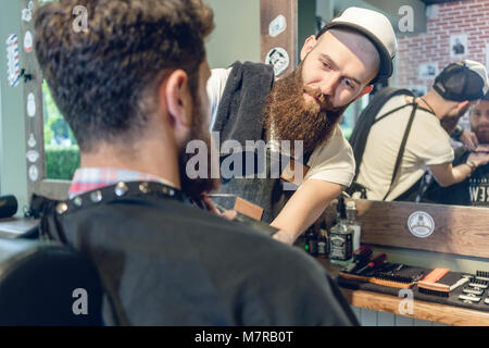 Close-up of the head of a young man and the hands of a hairstylist Stock Photo