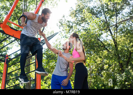 Young man doing dip exercise for triceps on gymnastic rings Stock Photo