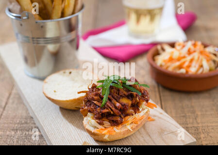 A vegan 'pulled pork' style slider made with jackfruit, plus a side of chips and coleslaw. Stock Photo