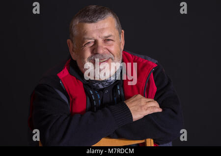 Nice low key portrait of bearded smiling senior man Stock Photo
