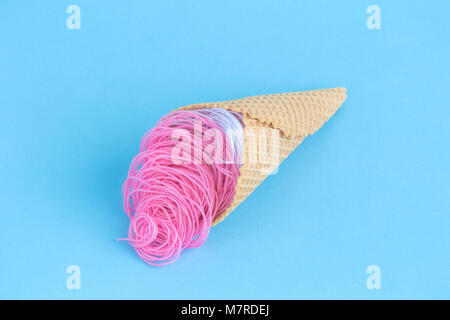 Fake ice cream made of threads on pastel blue background minimal concept. Stock Photo