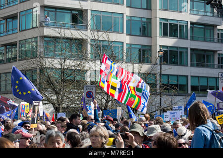 A crowd of anti Brexit protesters waving EU flags and a flag consisting of a set of flags of European Union at the Unite for Europe march in London Stock Photo
