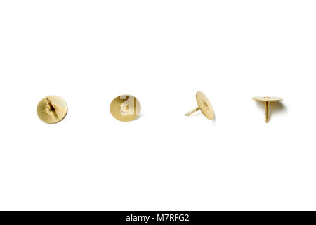 Small Collection Of 4 Brass Thumbtacks Arranged In A Line On White Background Stock Photo