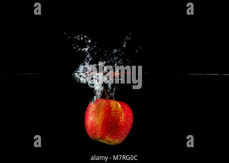 fresh red apple in water splash on black background Stock Photo