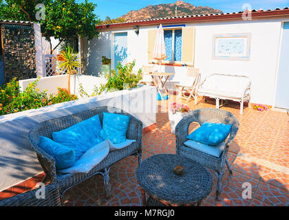 Cugnana, Italy - September 8, 2017: Courtyard garden with table and chairs at the house on Costa Smeralda resort, Sardinia, Italy Stock Photo