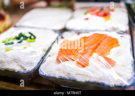 Macro closeup of plastic wrapped farmed salmon dip cream cheese on display in farmer's market Stock Photo