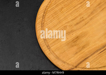 Empty cutting board on a stone dark surface, top view. Stock Photo