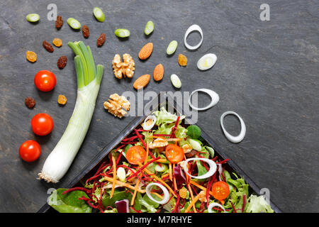 Salad ingredients with lettuce, cabbage, nuts and seeds on slate from above Stock Photo