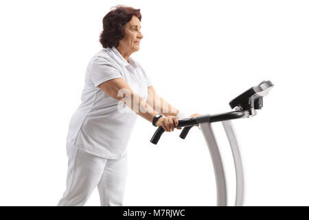 Mature woman walking on a treadmill isolated on white background Stock Photo