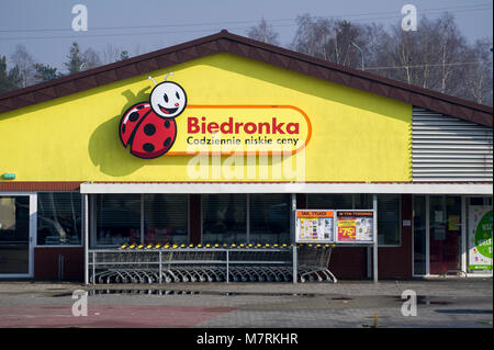 Parked shopping carts equipped with coin-operated locking mechanisms in Biedronka supermarket in the beginning of law restriction for Sunday shopping  Stock Photo