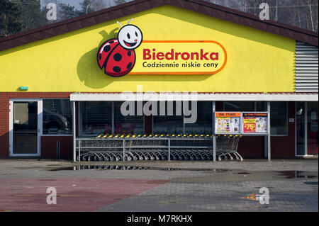 Parked shopping carts equipped with coin-operated locking mechanisms in Biedronka supermarket in the beginning of law restriction for Sunday shopping  Stock Photo