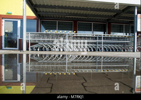 Parked shopping carts equipped with coin-operated locking mechanisms in Biedronka supermarket in the beginning of law restriction for Sunday shopping  Stock Photo