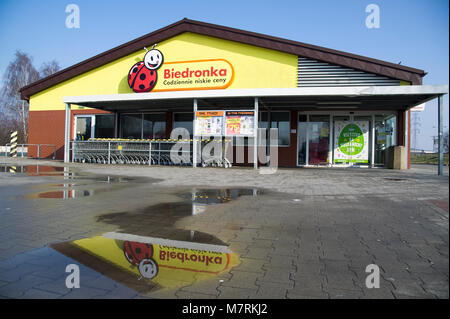 Parked shopping carts equipped with coin-operated locking mechanisms in Biedronka supermarket in the beginning of law restriction for Sunday shopping  Stock Photo